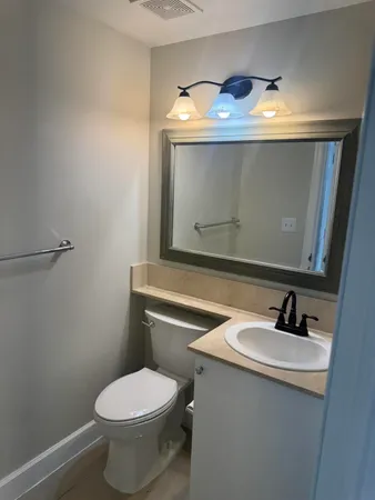 a bathroom with a sink toilet and mirror