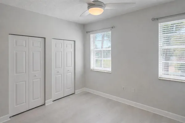 an empty room with windows and closet