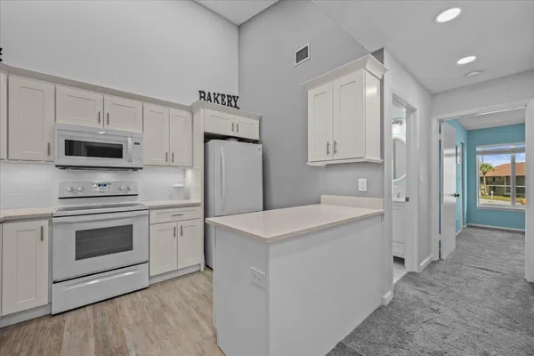 a kitchen with white cabinets and stainless steel appliances