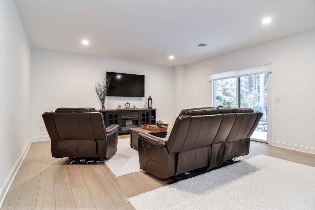 16 Barnes Boulevard, Unit 16 Hudson, MA 01749 - Photo 26 of 42 a living room with furniture and a flat screen tv