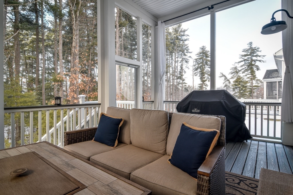 16 Barnes Boulevard, Unit 16 Hudson, MA 01749 - Photo 30 of 42 a living room with furniture and a floor to ceiling window