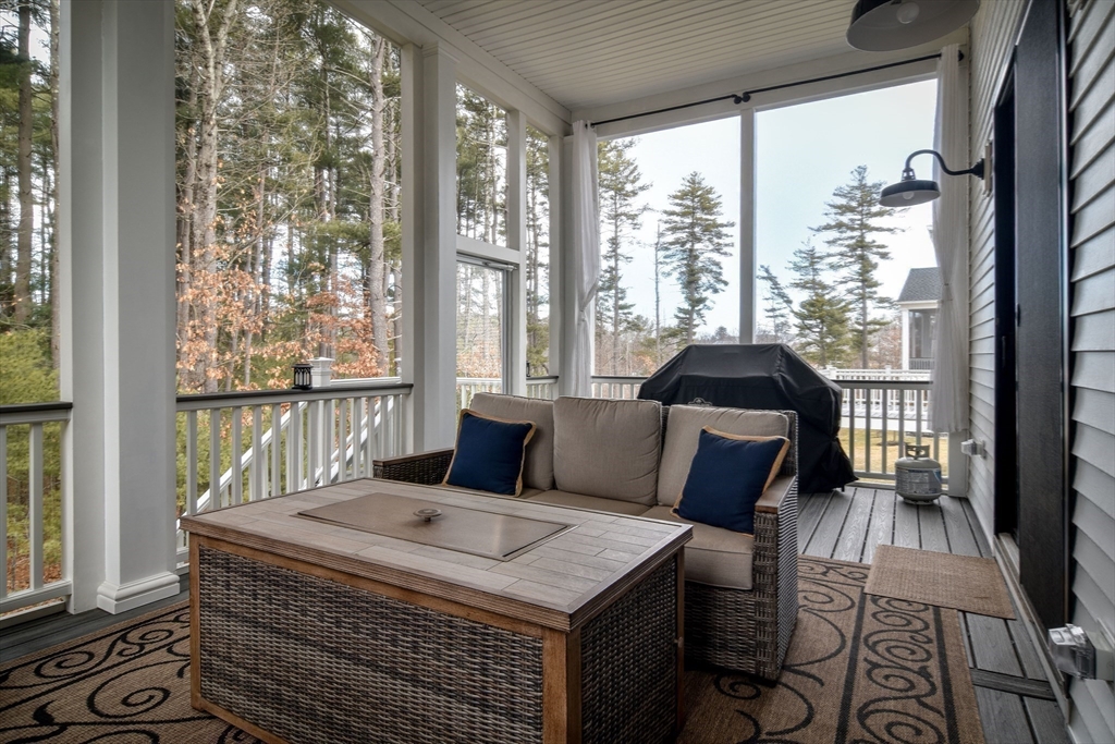 16 Barnes Boulevard, Unit 16 Hudson, MA 01749 - Photo 31 of 42 a living room with furniture and a floor to ceiling window