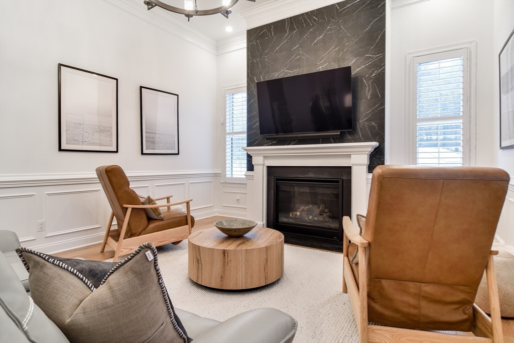 16 Barnes Boulevard, Unit 16 Hudson, MA 01749 - Photo 4 of 42 a living room with furniture a flat screen tv and a fireplace
