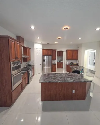 a spacious bathroom with a granite countertop sink and a mirror