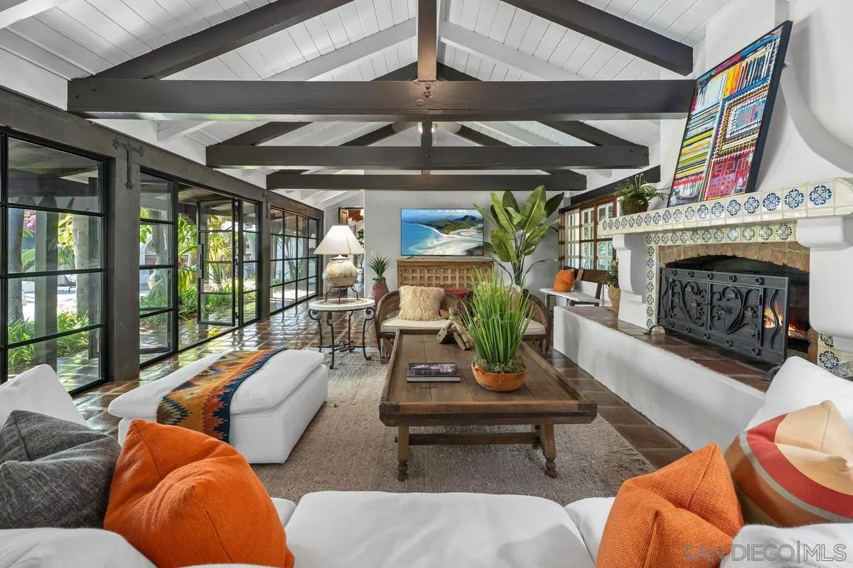 17507 Los Morros Rancho Santa Fe, CA 92067 - Photo 17 of 60 a living room with furniture a fireplace and a floor to ceiling window