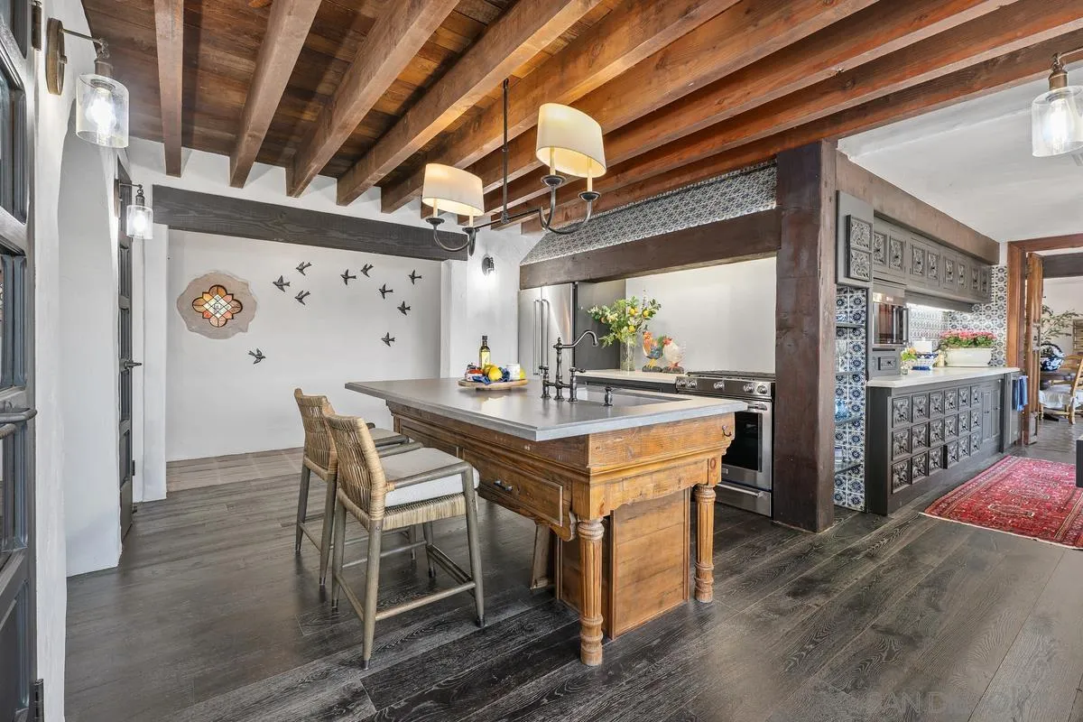 17507 Los Morros Rancho Santa Fe, CA 92067 - Photo 31 of 60 a kitchen with stainless steel appliances kitchen island granite countertop a table chairs and a refrigerator