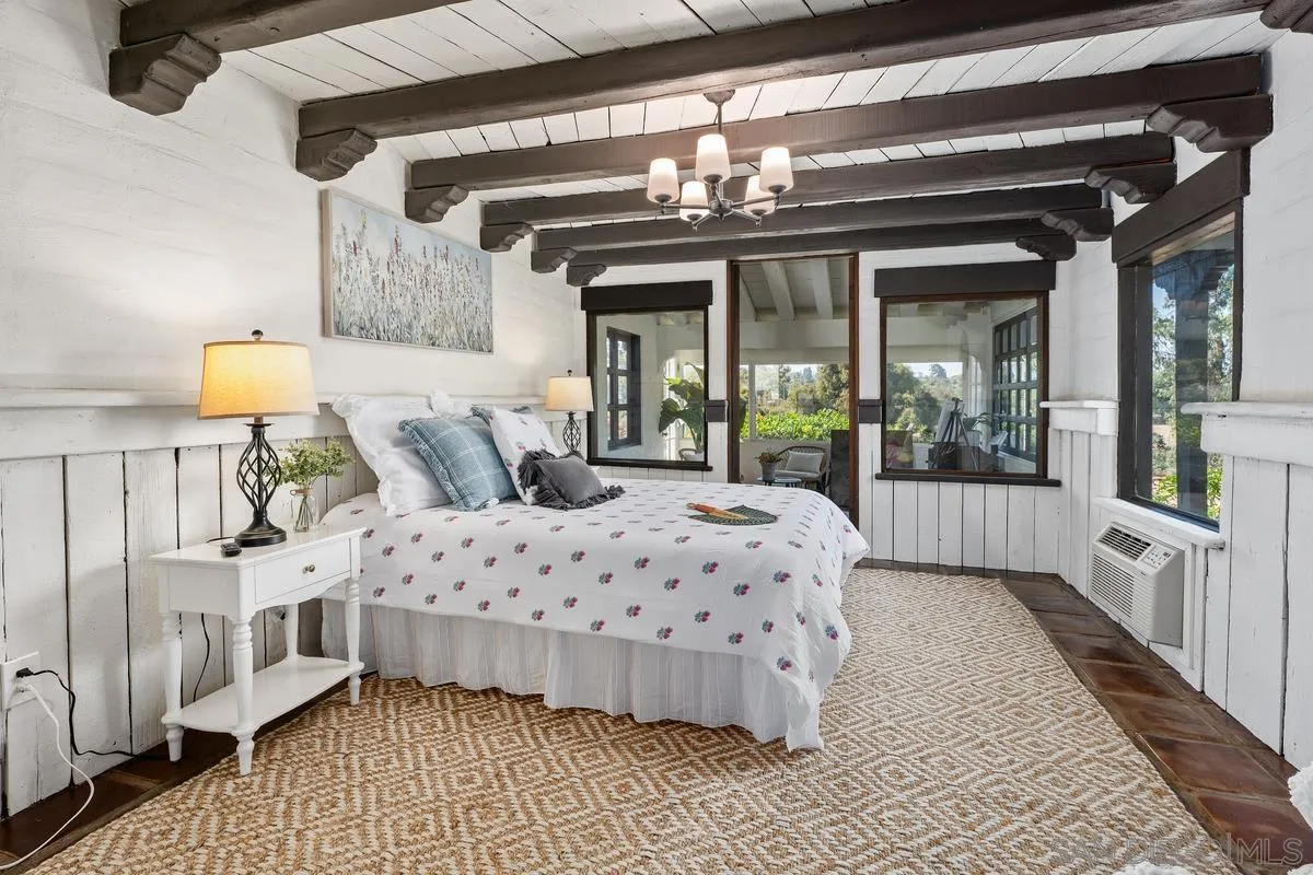 17507 Los Morros Rancho Santa Fe, CA 92067 - Photo 52 of 60 a bedroom with a large bed and a chandelier