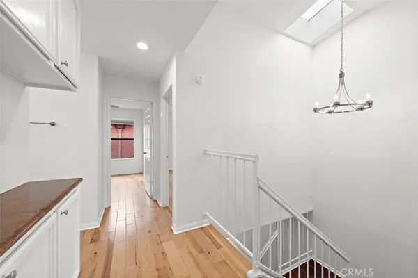 a view of a hallway with wooden floor and staircase