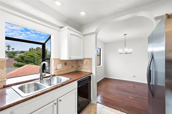 a kitchen that has a sink cabinets counter space and appliances