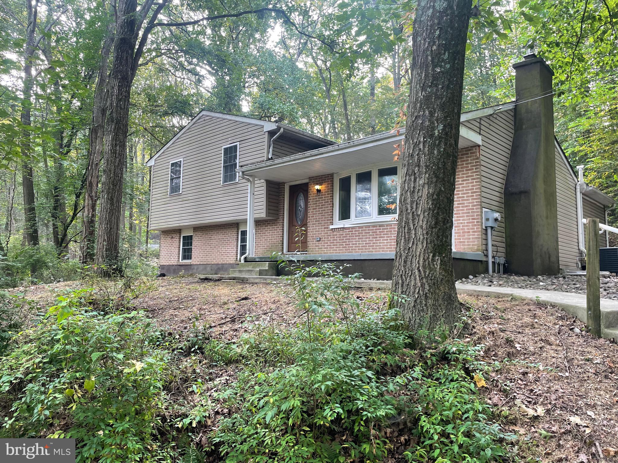 1300 Shadyside Road Downingtown, PA 19335 - Photo 1 of 17 a backyard of a house with large trees and brick walls