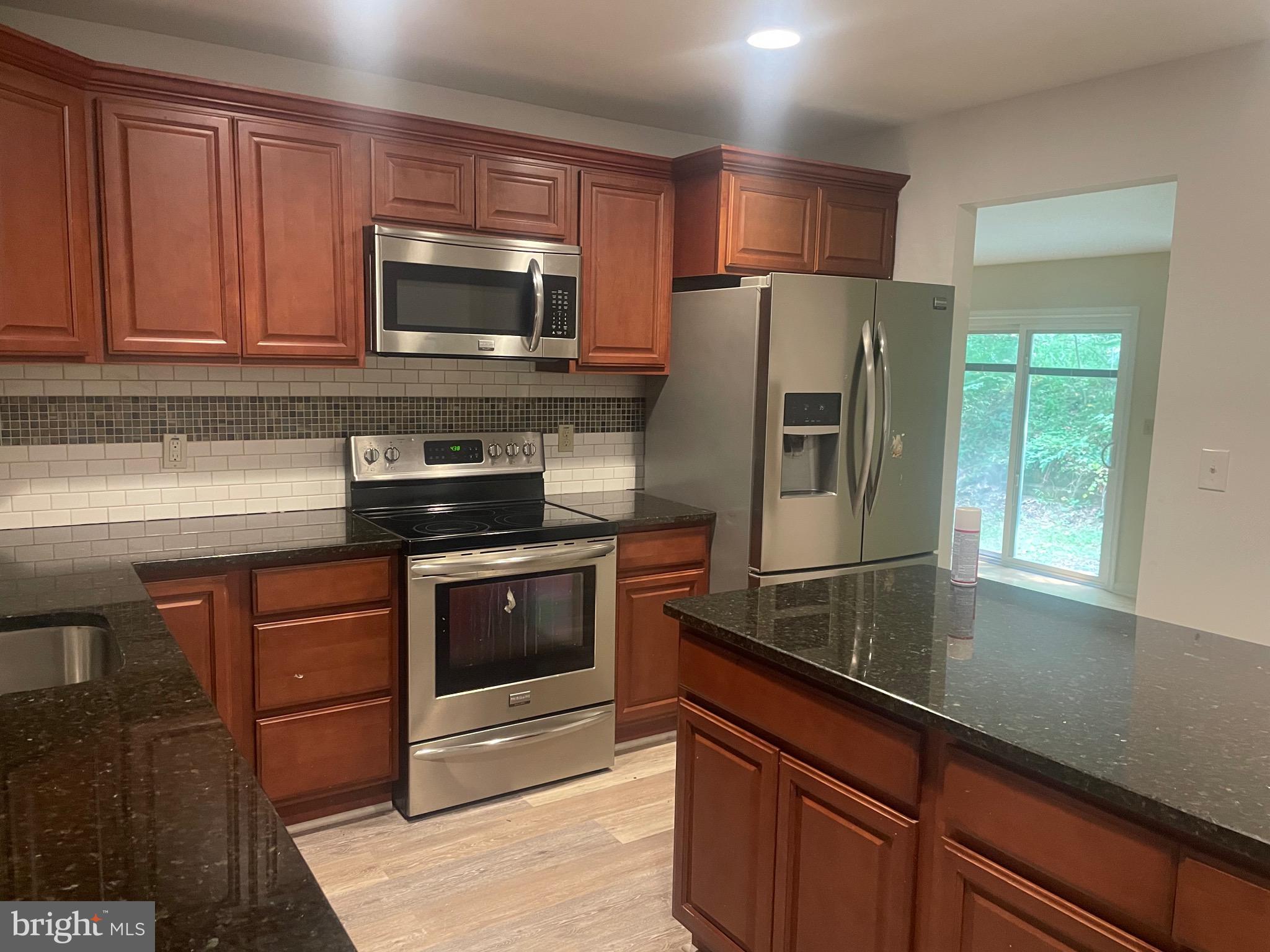 1300 Shadyside Road Downingtown, PA 19335 - Photo 15 of 17 a kitchen with granite countertop a refrigerator stove and microwave
