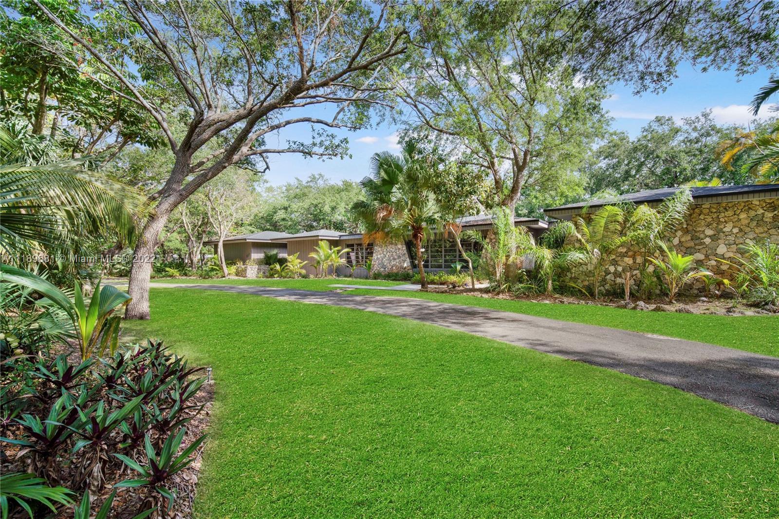 6465 Southwest 126th Street Road Pinecrest, FL 33156 - Photo 32 of 37 a garden view with a bench