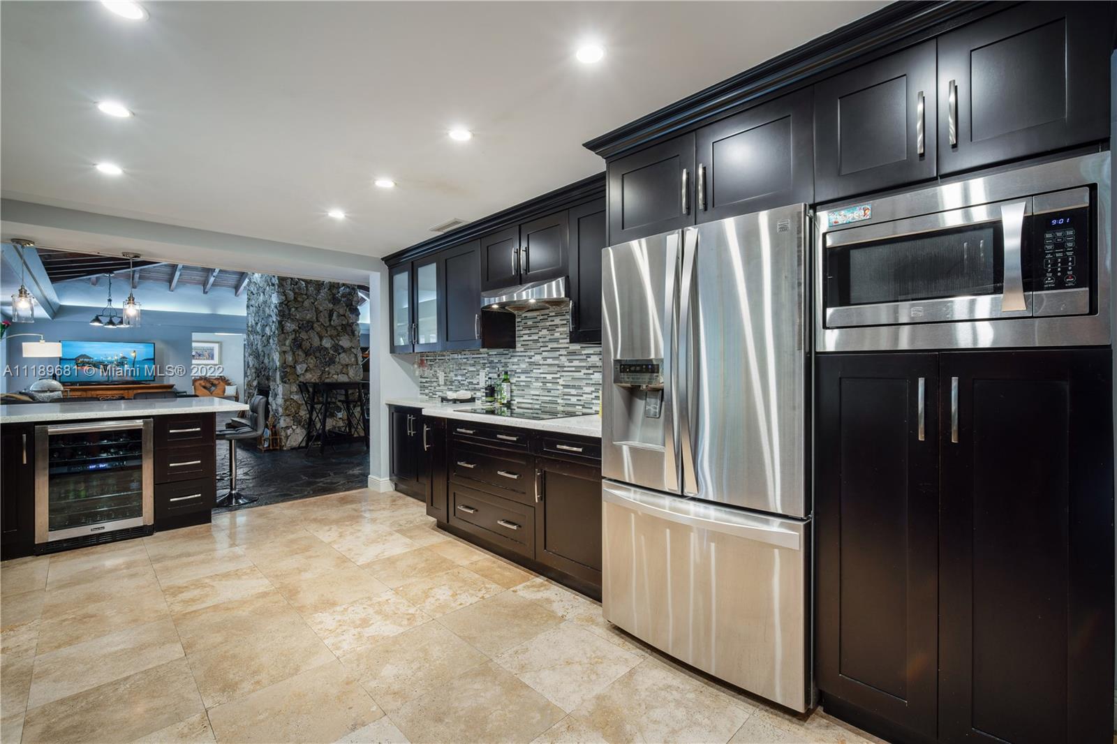 6465 Southwest 126th Street Road Pinecrest, FL 33156 - Photo 6 of 37 a kitchen with stainless steel appliances kitchen island granite countertop a refrigerator oven a sink and dishwasher