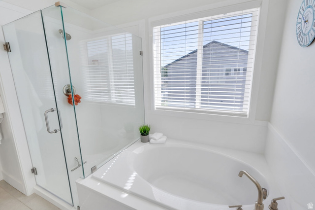2664 West Maple Street Mapleton, UT 84664 - Photo 23 of 49 Corner soaking tub with brushed nickel fixtures, accompanied by a glass-enclosed shower with a rainfall showerhead
