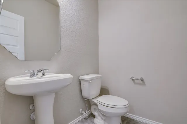 a bathroom with a sink toilet and a mirror