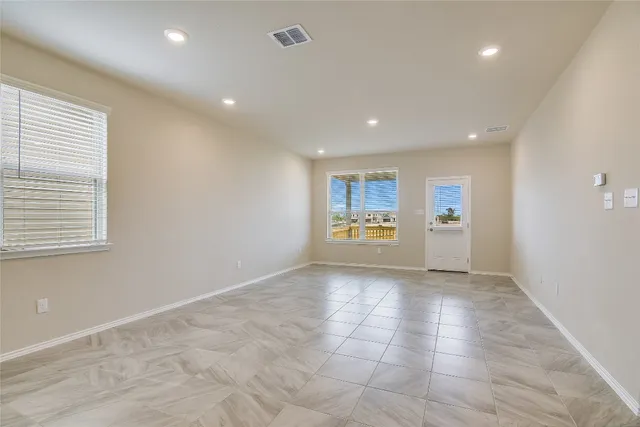 a view of a big room with wooden floor and windows
