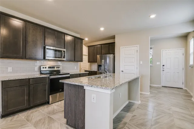 a kitchen with a sink stove and refrigerator