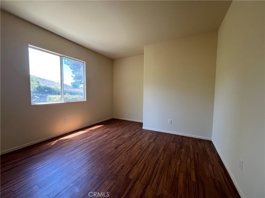 16200 Setting Sun Circle Riverside, CA 92503 - Photo 14 of 20 a view of an empty room with wooden floor and a window
