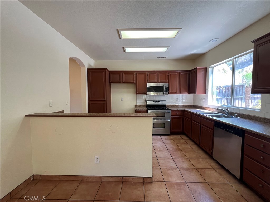 16200 Setting Sun Circle Riverside, CA 92503 - Photo 3 of 20 a large kitchen with a stove a sink dishwasher and a refrigerator
