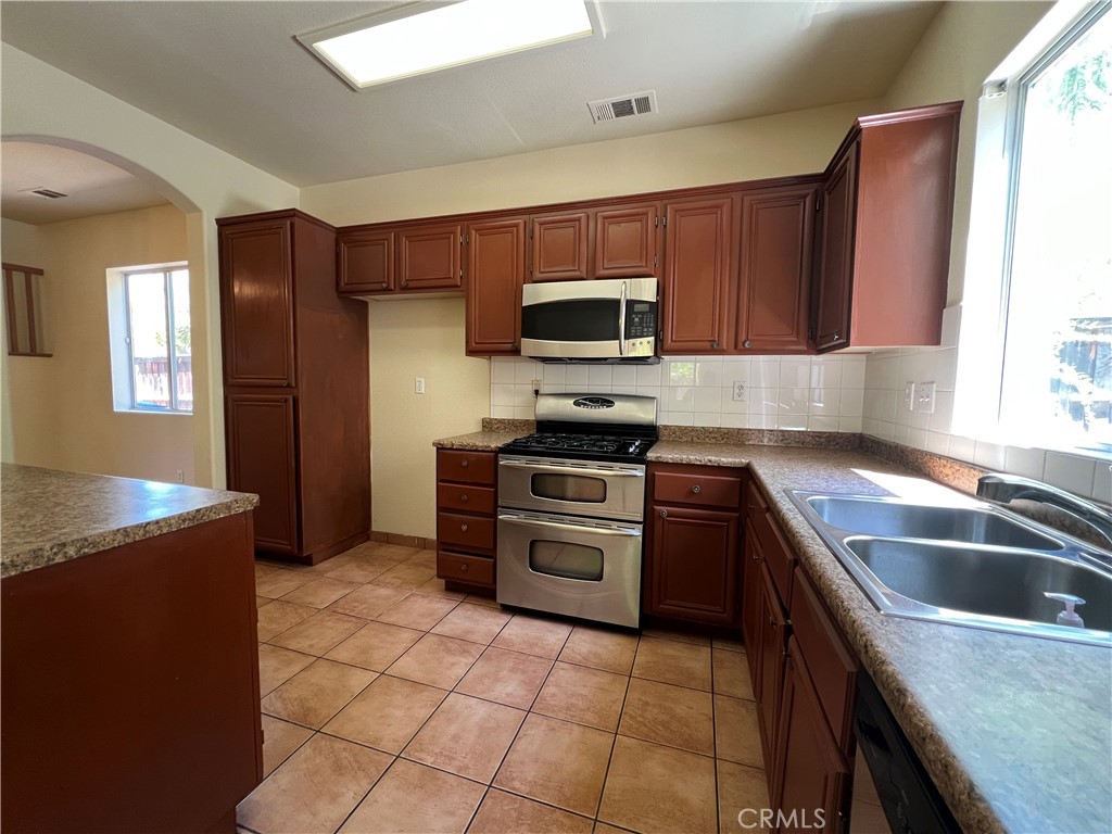 16200 Setting Sun Circle Riverside, CA 92503 - Photo 4 of 20 a kitchen with a sink stove and microwave