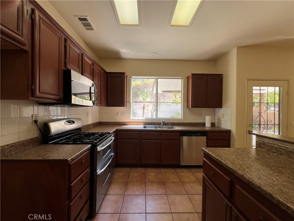 16200 Setting Sun Circle Riverside, CA 92503 - Photo 5 of 20 a kitchen with a stove a sink and a microwave
