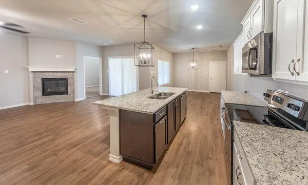 a kitchen with stainless steel appliances granite countertop a kitchen island a stove and a wooden floors
