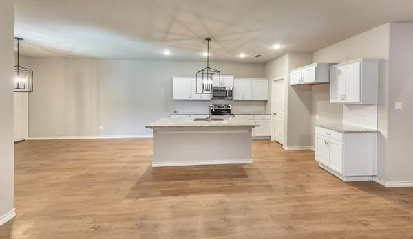 a kitchen with kitchen island a sink stainless steel appliances and cabinets
