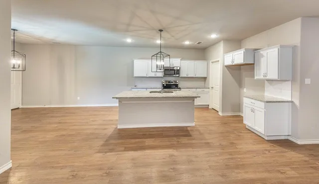 a kitchen with kitchen island a sink stainless steel appliances and cabinets