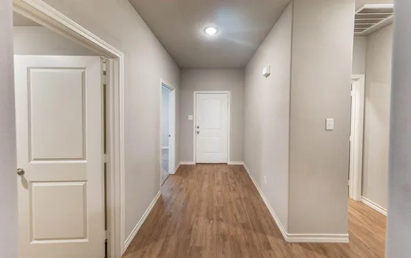 a view of a hallway with wooden floor