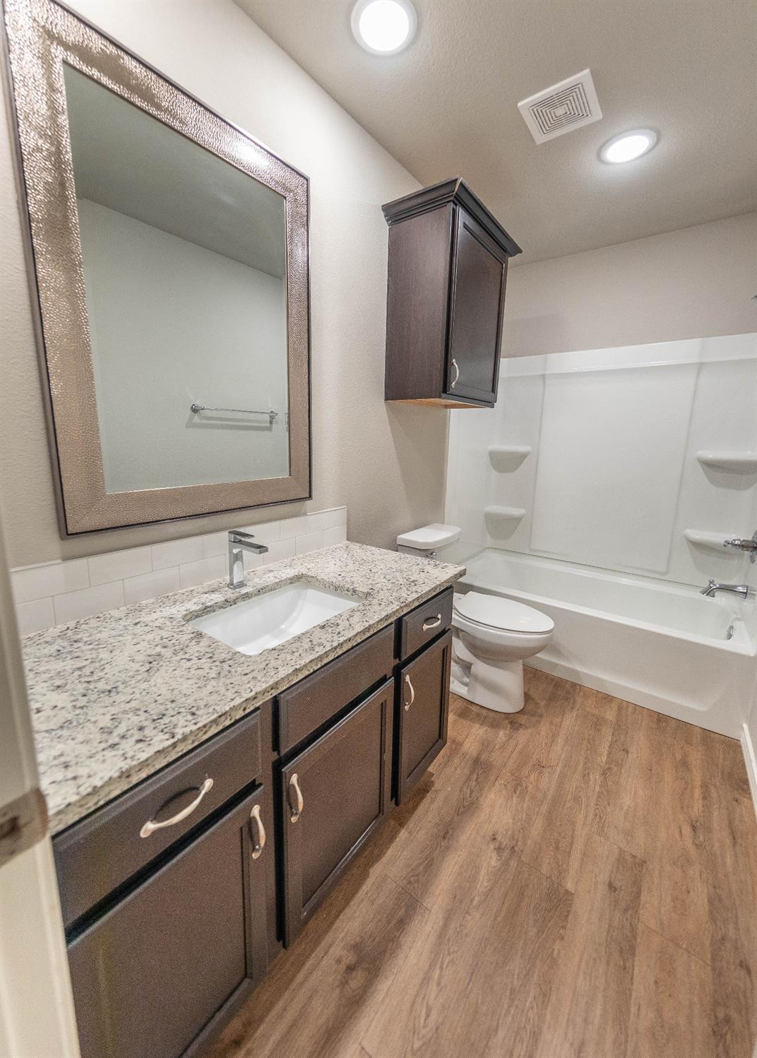 2545 137th Street Lubbock, TX 79423 - Photo 19 of 26 a bathroom with a granite countertop sink toilet and mirror
