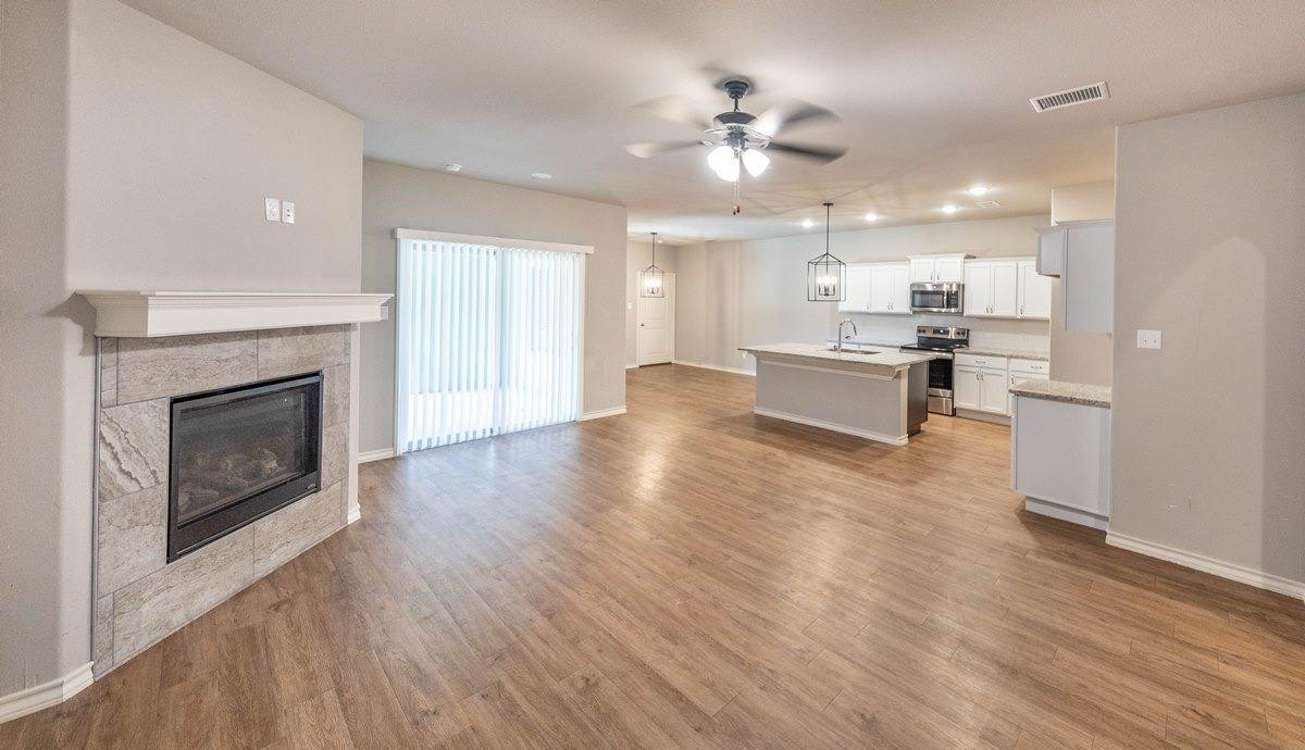 2545 137th Street Lubbock, TX 79423 - Photo 2 of 26 a large living room with stainless steel appliances a fireplace and chandelier