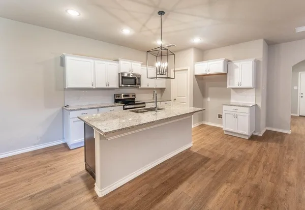 a kitchen with kitchen island white cabinets and stainless steel appliances