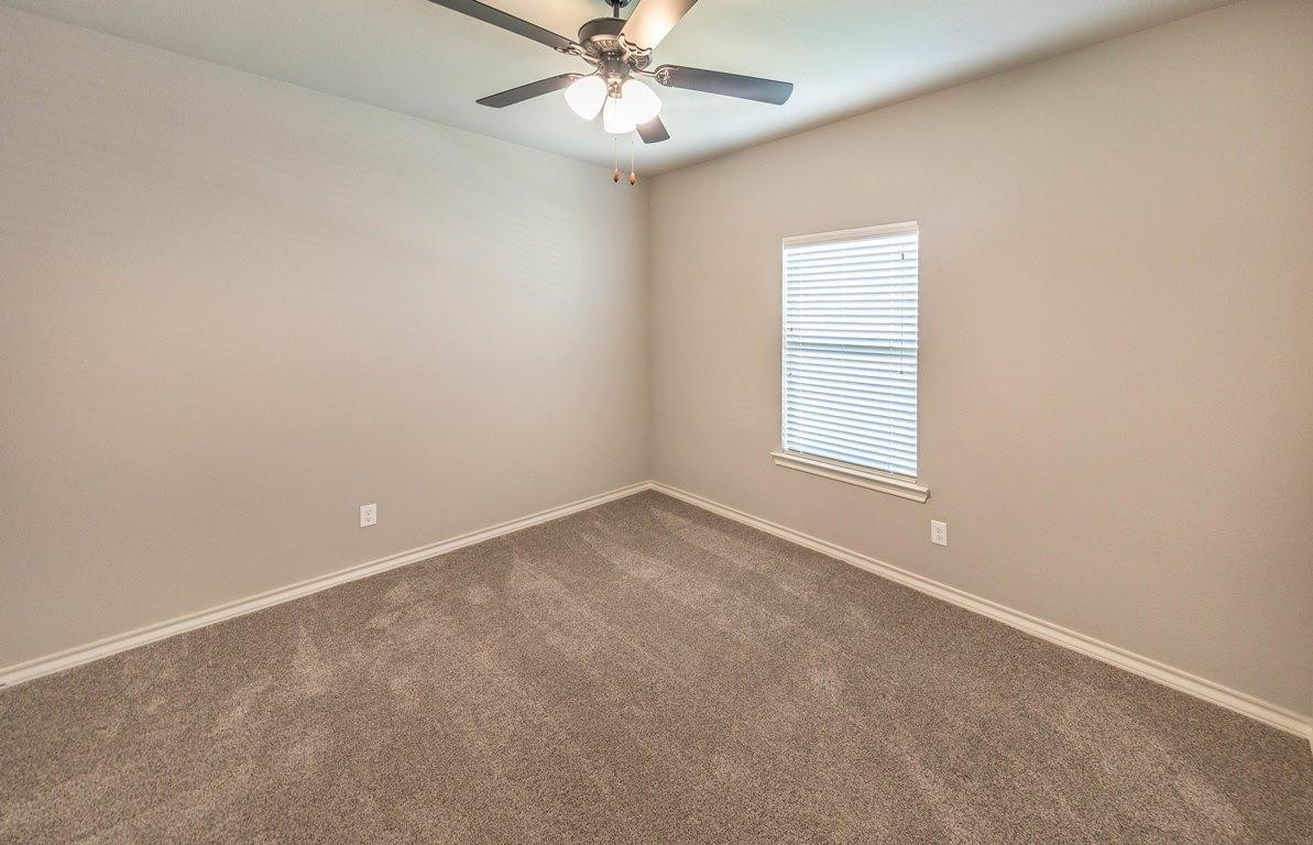 2545 137th Street Lubbock, TX 79423 - Photo 7 of 26 an empty room with a window and ceiling fan