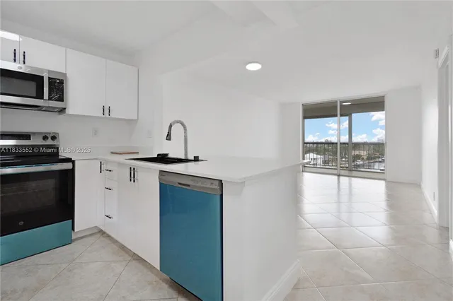 a kitchen with granite countertop a sink cabinets and stainless steel appliances