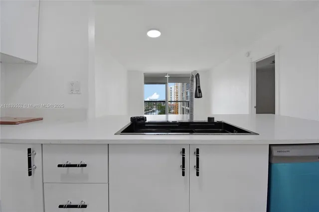a kitchen with stainless steel appliances granite countertop a sink a stove and white cabinets
