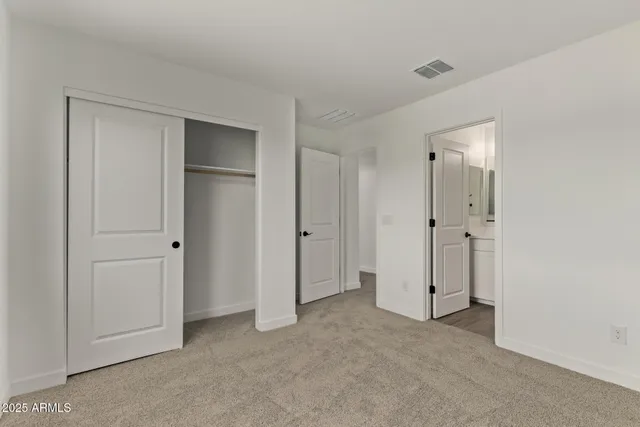 a view of an empty room with closet area