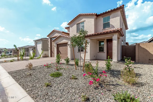 a front view of a house with plants
