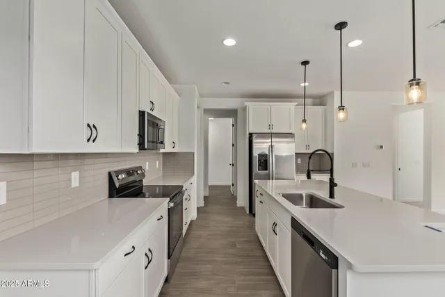 a open kitchen with stainless steel appliances granite countertop a sink a stove and a refrigerator