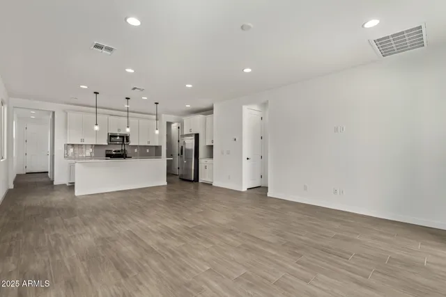 a view of a kitchen with refrigerator and white cabinets