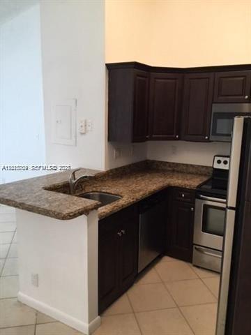 951 Lyons Road, Unit 6206 Coconut Creek, FL 33063 - Photo 4 of 27 a kitchen with granite countertop stainless steel appliances and wooden cabinets