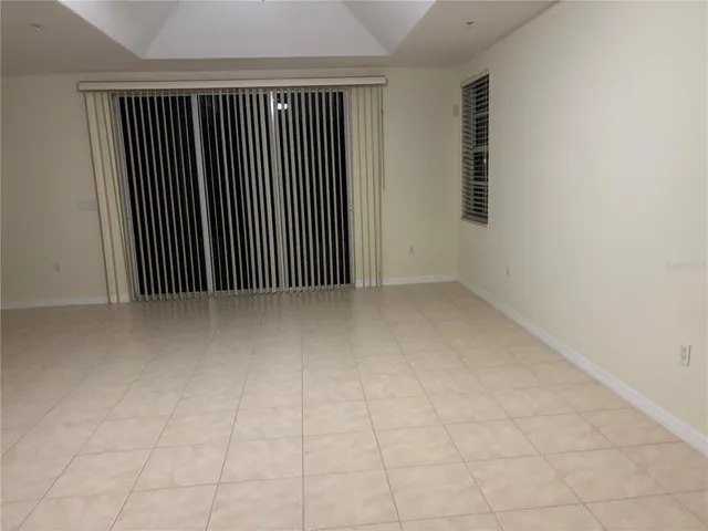 a view of an empty room with wooden floor and windows