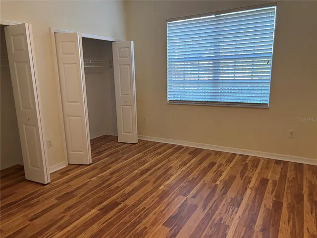 a view of a room with wooden floor and a window