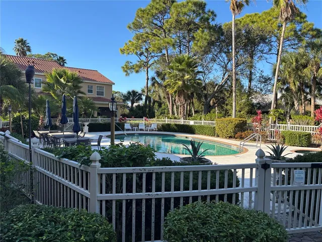 a view of a chair and tables under an umbrella