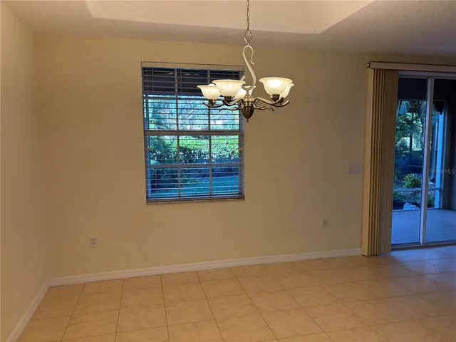 a view of a room with a chandelier fan and windows