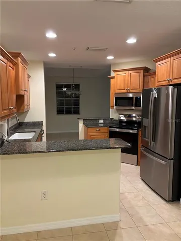 a kitchen with stainless steel appliances granite countertop a refrigerator and a stove