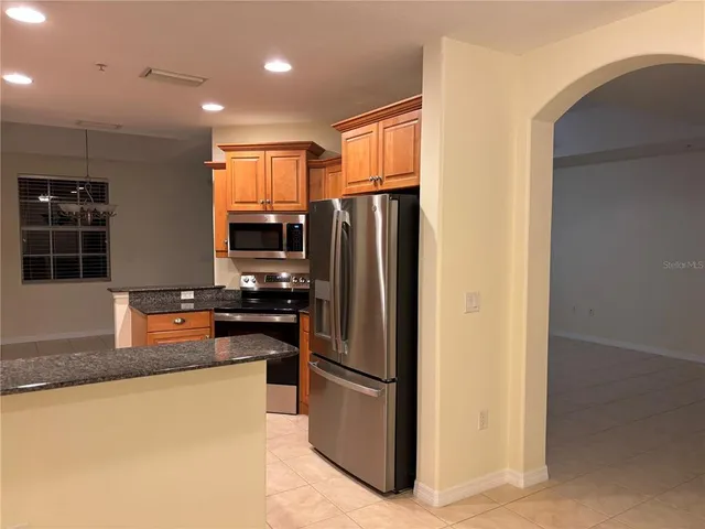 a kitchen with stainless steel appliances granite countertop a stove a sink and a microwave