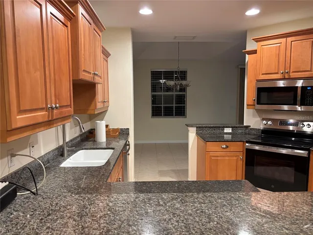 a kitchen with stainless steel appliances granite countertop a sink a stove and a microwave