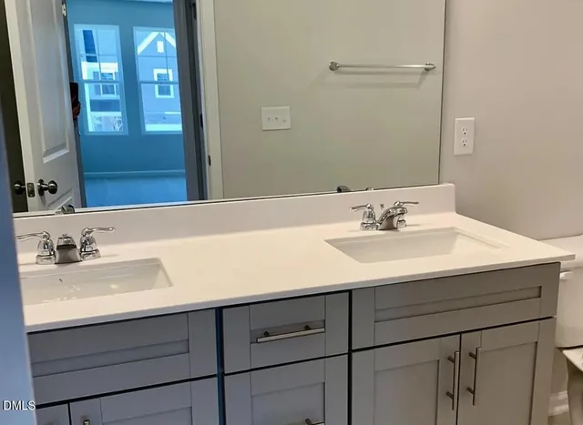 a bathroom with a granite countertop toilet a sink and a shower