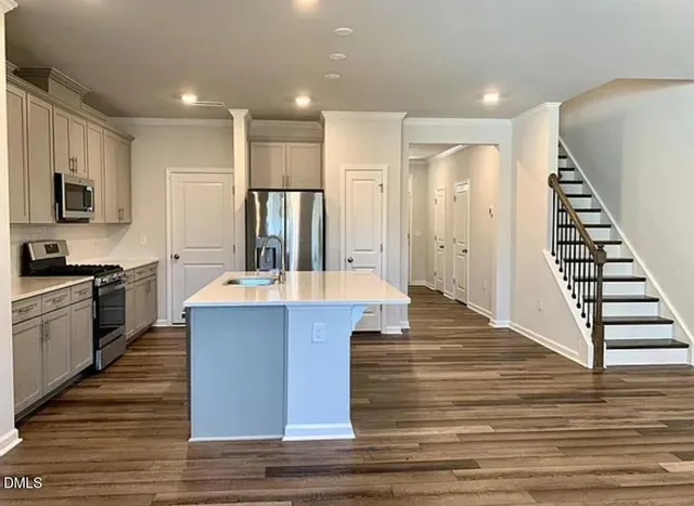 a large kitchen with stainless steel appliances kitchen island a large counter top and sink