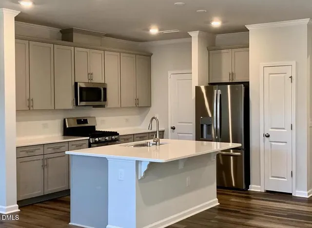 a kitchen with stainless steel appliances granite countertop a refrigerator sink and stove